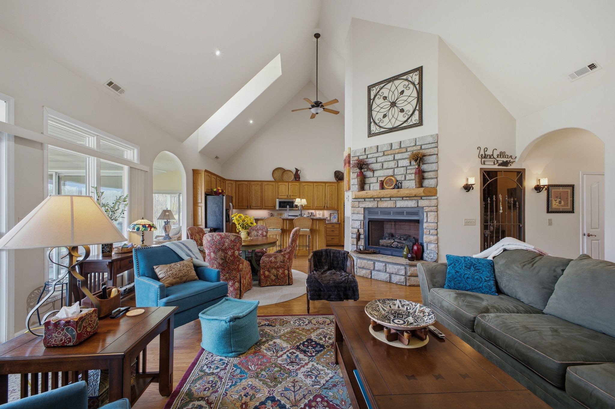 Open-concept great room, kitchen, and stone fireplace