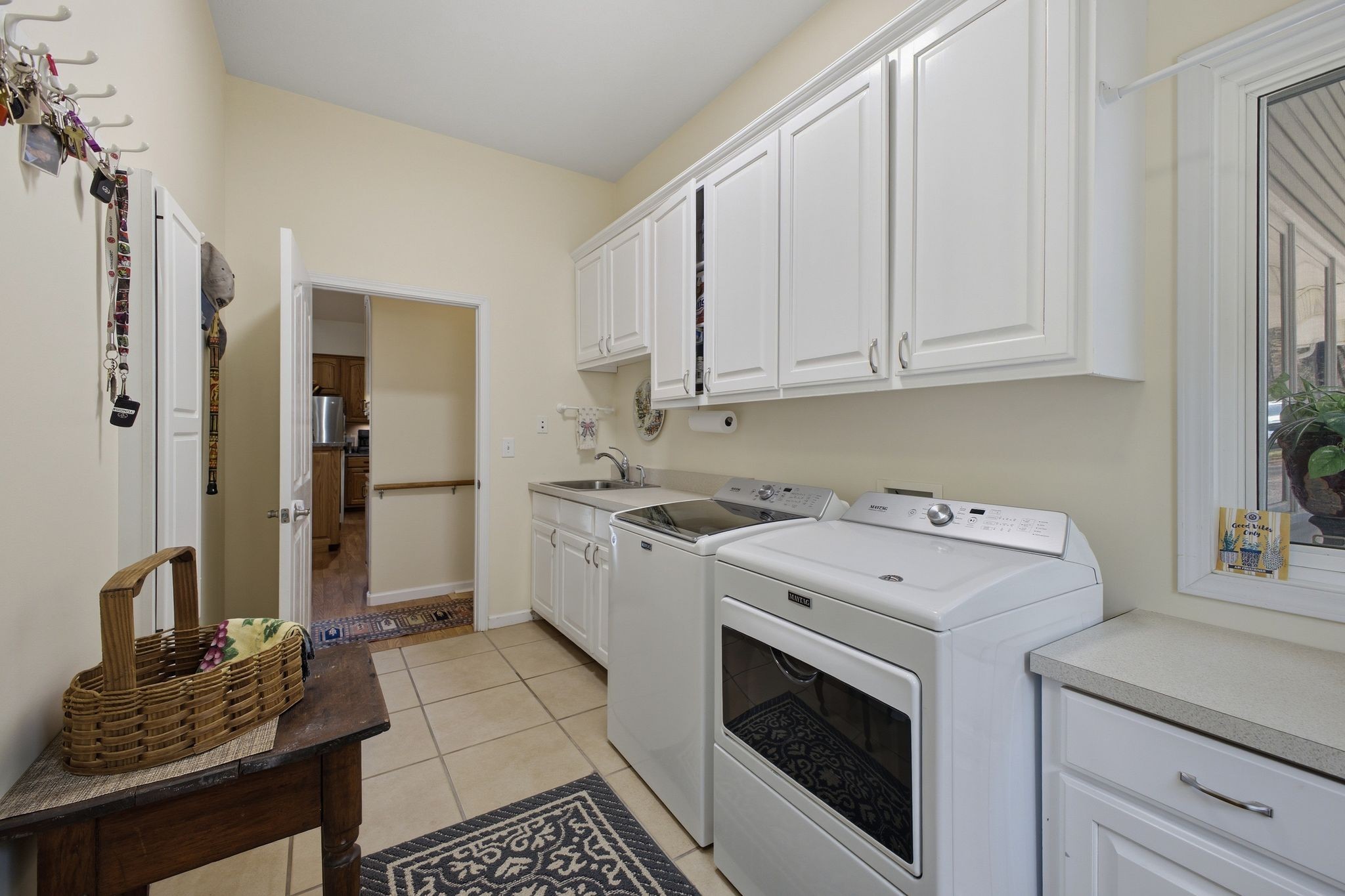 Oversized laundry room with utility sink and cabinetry